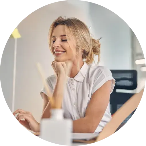 Picture of a woman smiling as she scrolls through her computer