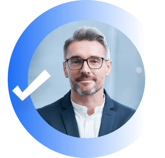 A man with gray hair wearing glasses and a navy blazer smiling for a picture.