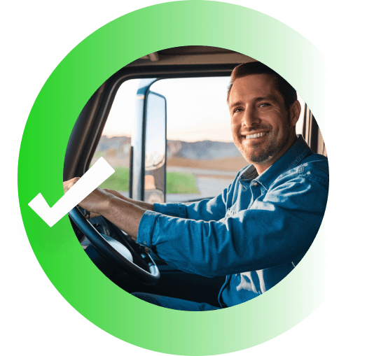 Man smiling while driving a truck in an open field