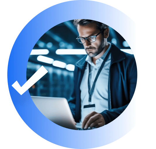 it professional working on a laptop in a secure data center with a blue circle and checkmark