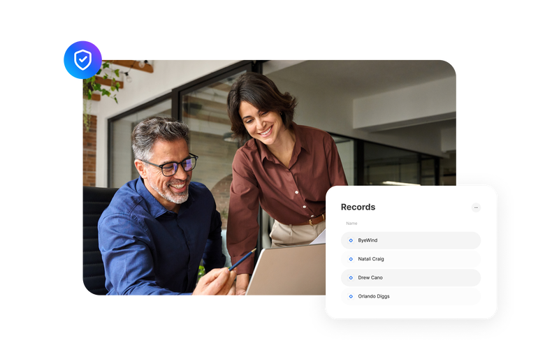 coworkers reviewing information together on a laptop with a digital records panel displayed
