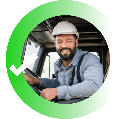Smiling construction worker wearing a hard hat sitting in a truck cab inside a green circle with a checkmark