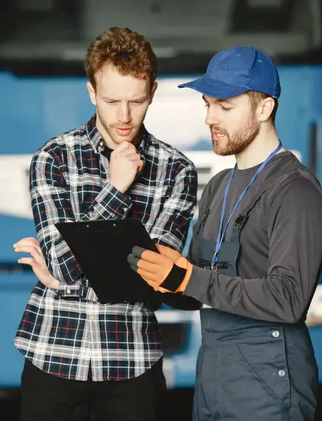 Two employees looking intently at a clipboard
