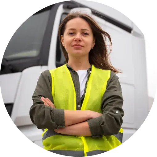 confident worker in a safety vest standing with arms crossed in front of a truck